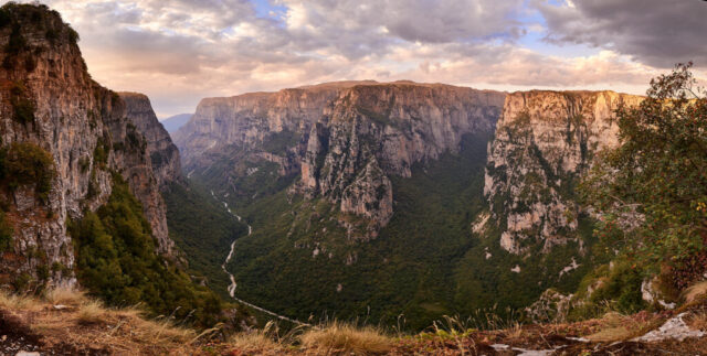 Landscape photograph of Vikos Gorge in Greece at sunset taken from Oxya Viewpoint showing deep canyon and dramatic light