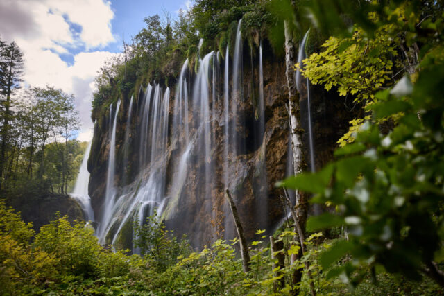 Handheld Long exposure image of waterfalls in Plitvice Lakes National Park in Croatia during daytime with green forest surroundings